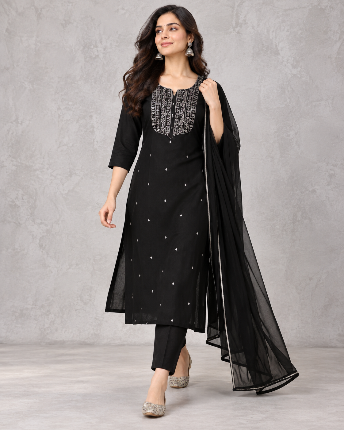 Model walking in the black salwar suit, highlighting the flow of the dupatta.