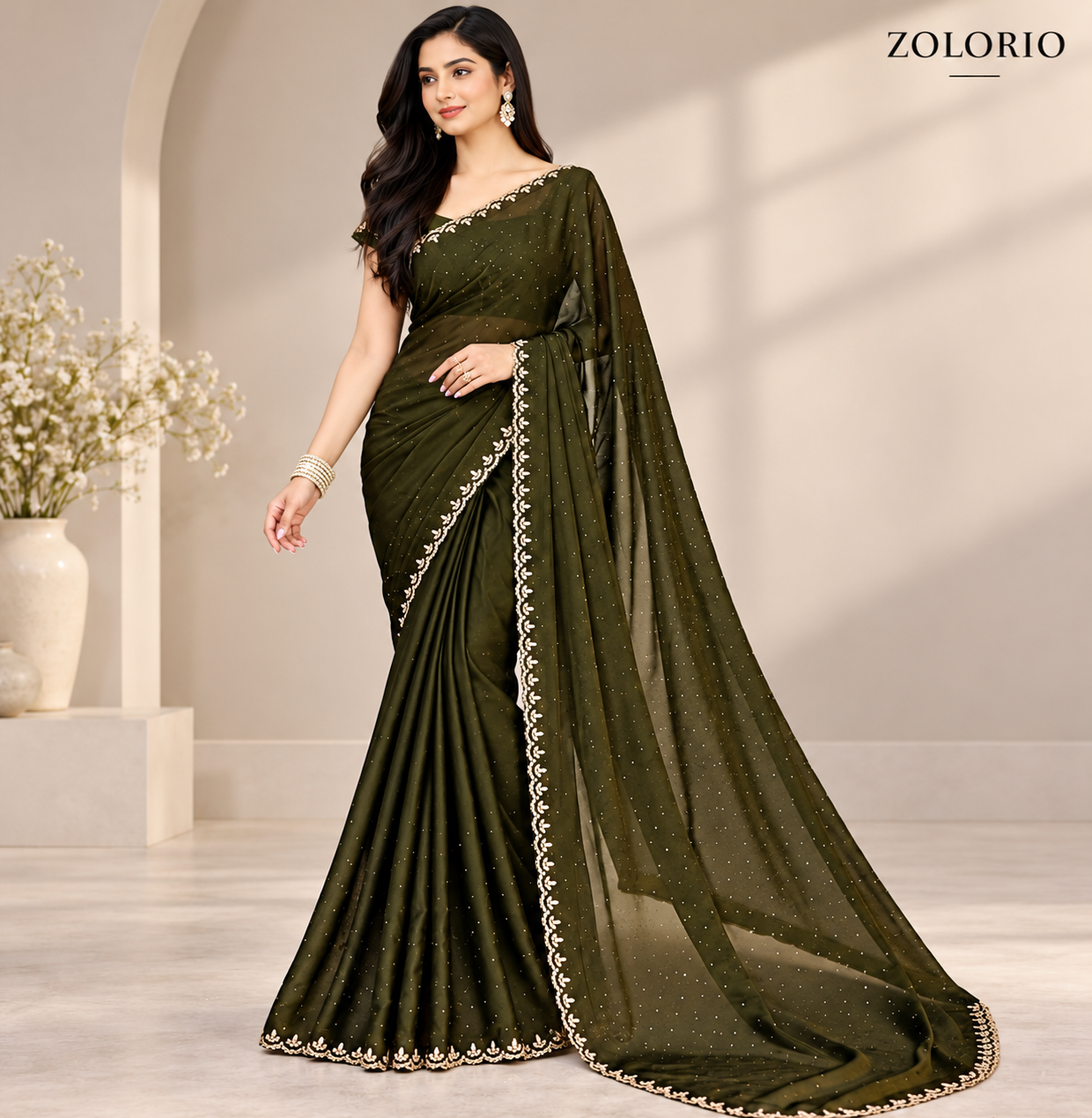 Model holding the sheer drape of the olive green saree, showing the intricate border details.